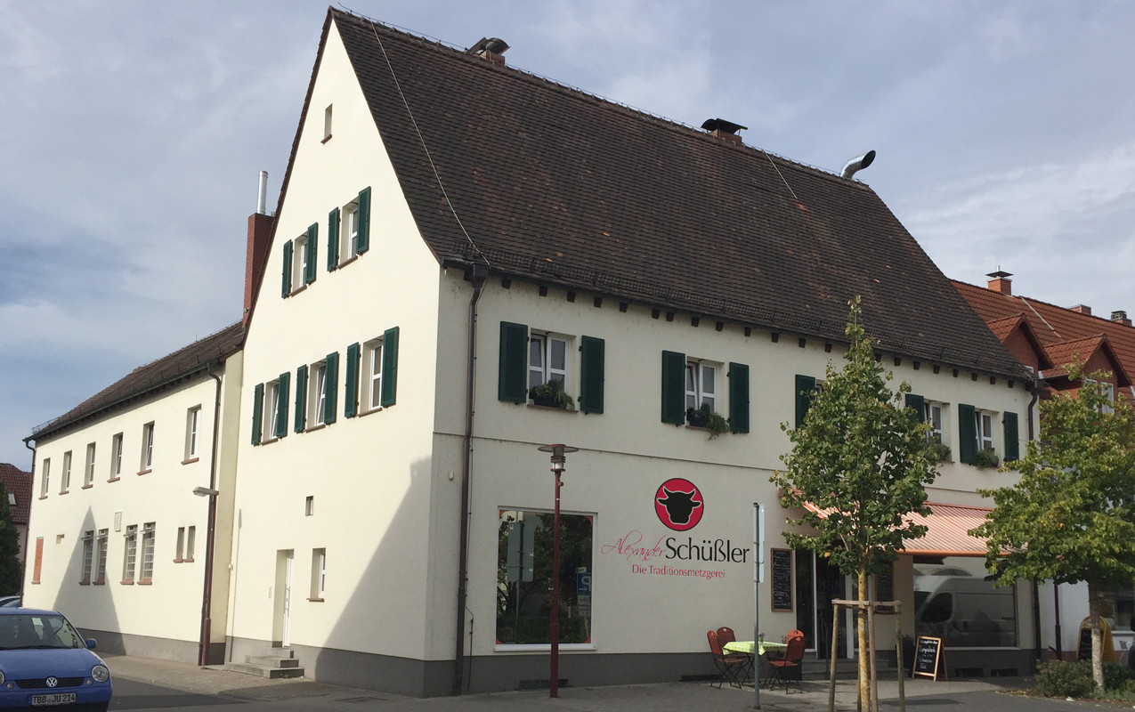 Foto der Metzgerei Schüssler Filiale in Erlenbach. Hausansicht, freundlicher blauer Himmel.