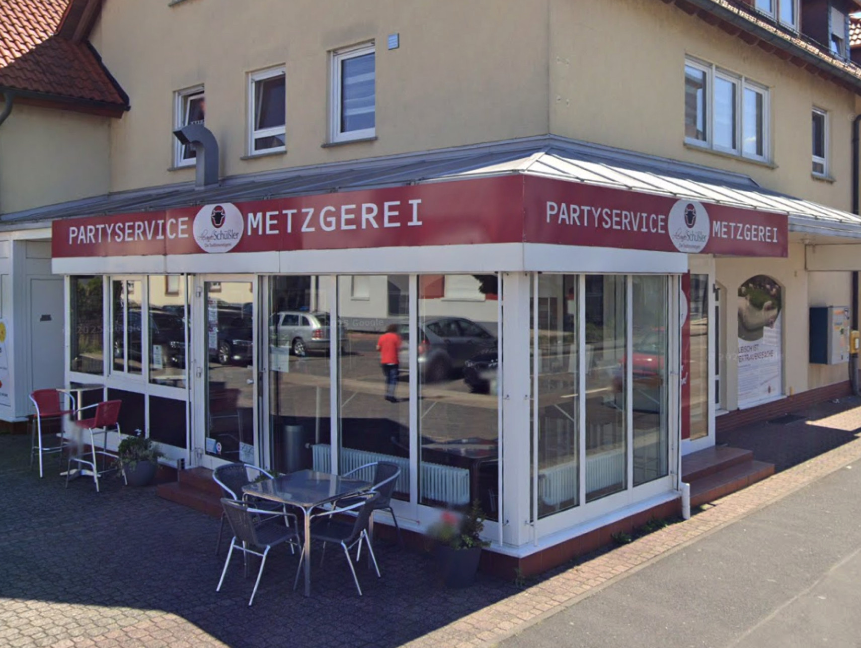 Foto der Metzgerei Schüssler Filiale in Elsenfeld. Hausansicht mit davor liegender Straße.