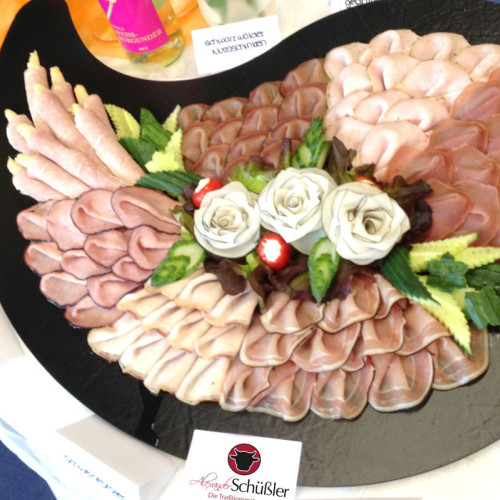 Aufschnittplatte mit Schinken- und Wurstsorten, verziert mit Rettich-Rosen.