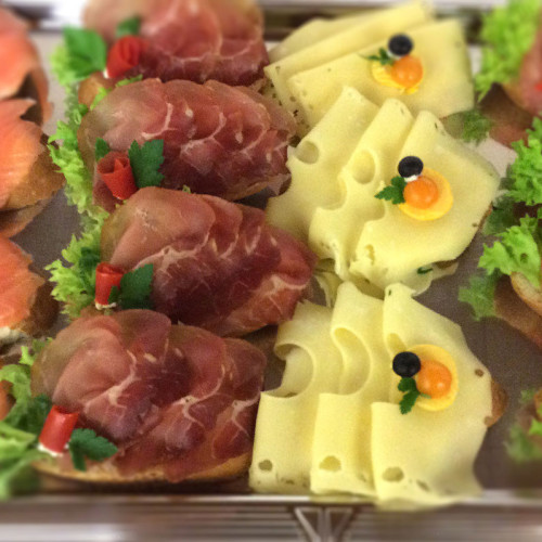 Häppchen mit Rohschinken, Käse auf einer Catering-Platte.